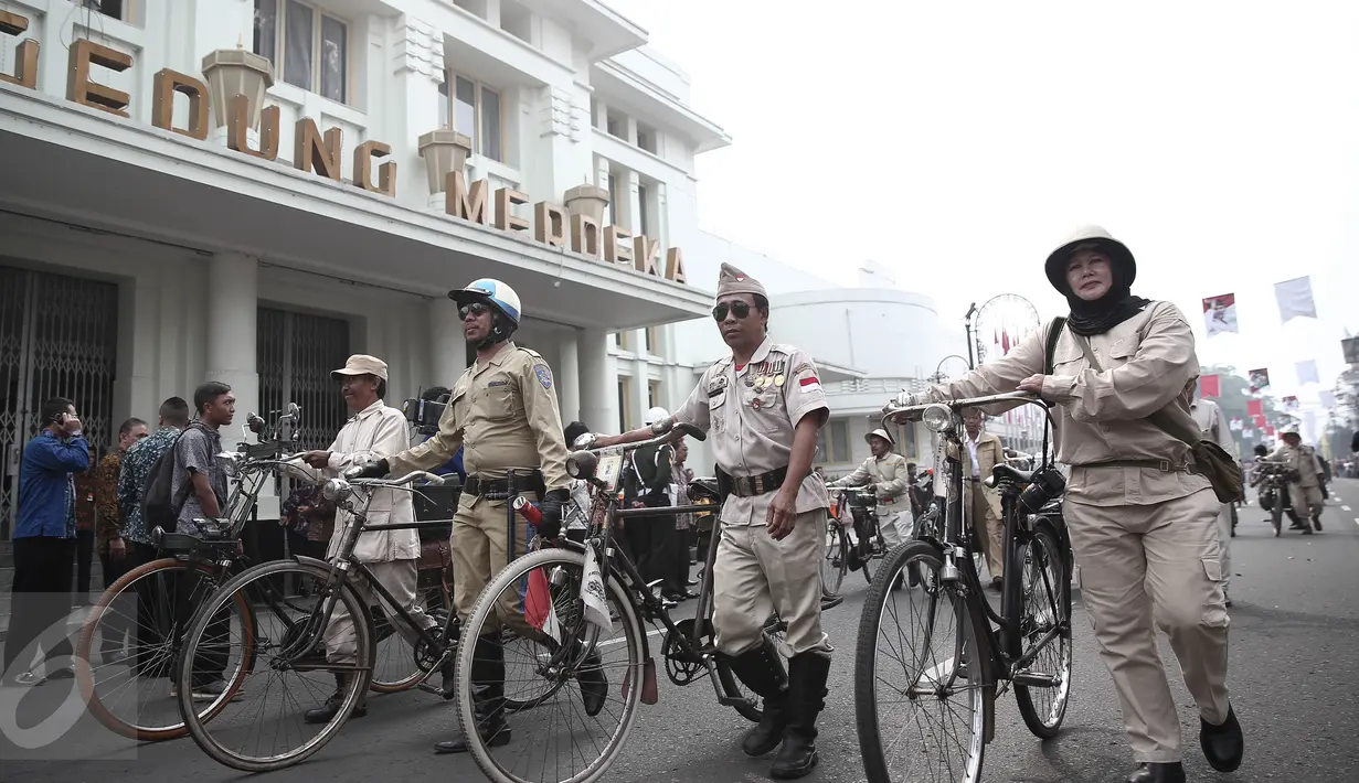 Aksi peserta parade menggunakan sepeda kuno lengkap dengan atribut untuk menuju Gedung Merdeka, Bandung, Jawa Barat, Rabu (1/6/2016). Kegiatan ini untuk memperingati momen bersejarah yang dialami oleh bangsa Indonesia. (Liputan6.com/Faizal Fanani)