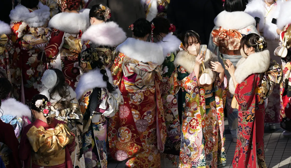 Perempuan Jepang berkimono yang merayakan ulang tahun ke-20 antre memasuki tempat untuk berpartisipasi dalam upacara resmi, yang biasa disebut upacara Kedewasaan di Yokohama dekat Tokyo, Senin (9/1/2023). Jepang menurunkan usia dewasa dari 20 tahun menjadi 18 tahun pada 2022. (AP Photo/Eugene Hoshiko)