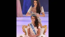 Miss World 2013, Megan Young saat memakaikan mahkota berwarna biru di atas kepala Rolene Strauss di London, Minggu (14/12/2014). (AFP PHOTO/Leon Neal)