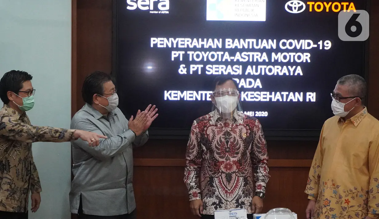 Menteri Kesehatan Terawan Agus Putranto (kedua kanan) disaksikan Presdir PT Toyota Astra Motor (TAM) Susumu Matsuda (kedua kiri) saat mencoba face shield yang merupakan bantuan dari TAM dan PT Serasi Autoraya (SERA) untuk penanganan Covid-19 di Jakarta Rabu (20/5/2020). (Liputan6.com/HO/Ady)