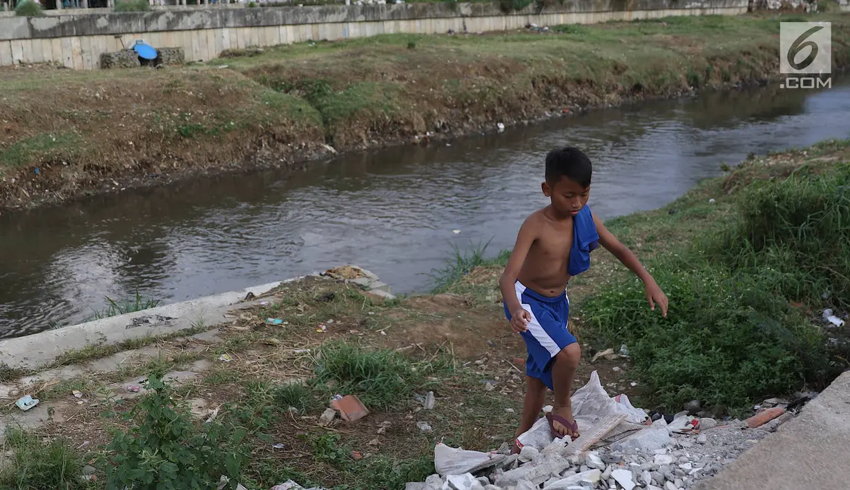 Seorang anak beraktivitas di sekitar aliran Kali Ciliwung, Jakarta, Selasa (26/3). Normalisasi Kali Ciliwung terganjal pembebasann lahan yang dikuasai warga. Pemprov DKI Jakarta menargetkan tahun 2019 masalah pembebasan tuntas. (Liputan6.com/Immanuel Antonius)