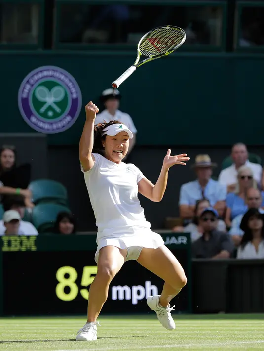 Ekspresi petenis Jepang Kurumi Nara saat raketnya terlepas dari tangan mengembalikan bola pukulan Petenis Rumania Simona Halep saat bertanding pada hari kedua tunggal putri Kejuaraan Tenis Wimbledon di London, (3/7). (AP Photo / Ben Curtis)