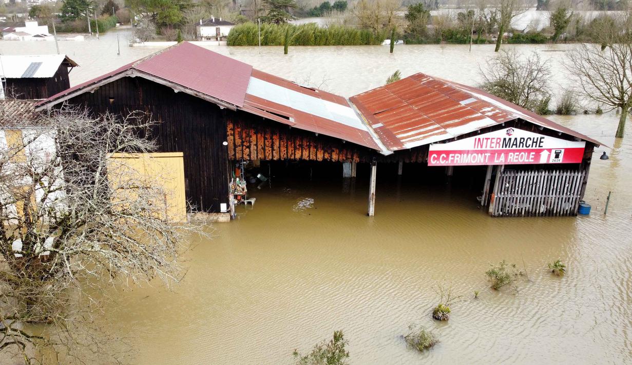 Empat departemen di Prancis barat ditempatkan di bawah siaga merah atas risiko banjir. Tampak foto udara yang menunjukkan air banjir di sekitar garasi di La Reole, Prancis barat daya, Prancis barat pada Kamis 19 Februari 2026. (ROMAIN PERROCHEAU/AFP)