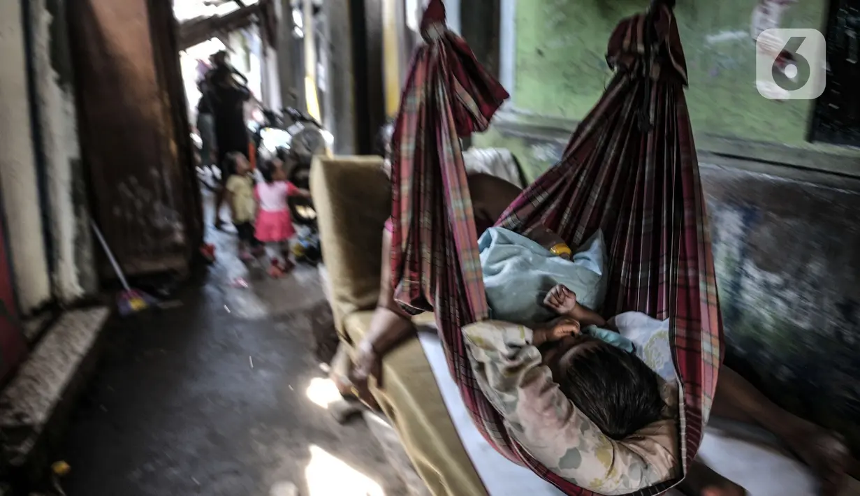Seorang anak tertidur di atas ayunan buatan di permukiman padat penduduk di kawasan Cakung, Jakarta, Senin (15/2/2021). Jika dibandingkan dengan September 2019, jumlah penduduk miskin di perkotaan naik 1,32 persen, sedangkan di perdesaan naik 0,60 persen. (merdeka.com/Iqbal S Nugroho)