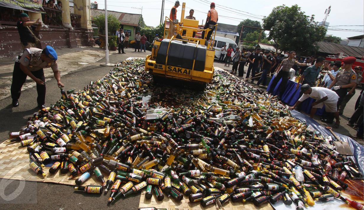 Petugas memusnahkan barang bukti narkotika dan miras ilegal di halaman Polsek Metro Palmerah, Jakarta, Rabu (22/6). Petugas menangkap tujuh tersangka dengan total omset mencapai Rp5.780.550.000. (Liputan6.com/Immanuel Antonius)