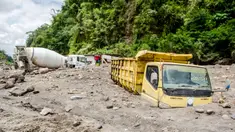 Truk milik penambang pasir tertimbun abu vulkanik setelah hujan deras mengguyur lereng Gunung Merapi di Magelang, 2 Desember 2021. Sejumlah truk tambang tertimbun lahar dingin Gunung Merapi. (AGUNG SUPRIYANTO/AFP)