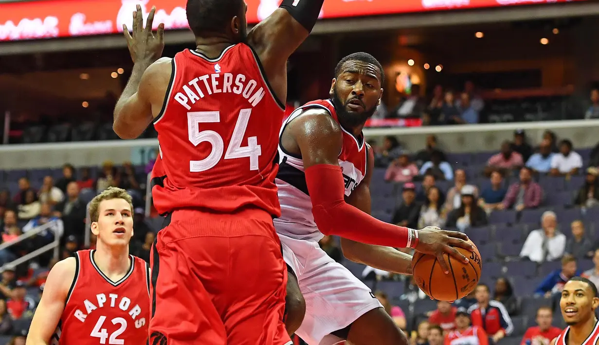 Aksi pemain Washington Wizards, John Wall (kanan) saat melewati hadangan pemain Toronto Raptors, Patrick Patterson #54 pada laga NBA Preseason di Verizon Center, Ssabtu (22/10/2016) WIB. (Mandatory Credit: Brad Mills-USA TODAY Sports)