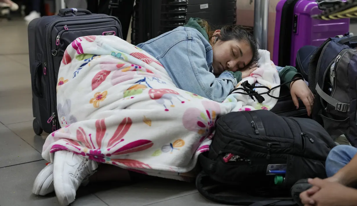 Penumpang maskapai Viva Air tidur di bandara setelah maskapai berbiaya rendah itu menangguhkan operasinya di Bandara Internasional El Dorado di Bogota, Kolombia, Selasa (28/2/2023). Viva Air, di situs webnya, "dengan menyesal mengumumkan penangguhan operasinya, karena keterlambatan dalam definisi aliansi yang tepat waktu yang akan memungkinkan integrasinya dengan grup maskapai yang lebih kuat dan lebih besar." (AP Photo/Fernando Vergara)