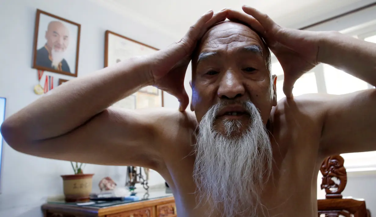 Master Li Liangui bersiap sebelum memulai latihan di sebuah taman di kediamannya di Beijing, China  pada 30 Juni 2016. Selama 50 tahun, Li Liangui telah mendalami ilmu seni bela ini. (REUTERS/Kim Kyung-Hoon)