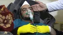 Seorang pria mendapatkan perawatan setelah diduga terkena serangan gas beracun di sebuah kota yang dikuasai pemberontak di Suriah, Selasa (4/4). Akibatnya, sedikitnya 35 orang tewas, termasuk beberapa anak. (Mohamed al-Bakour/AFP)