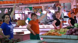 Ekspresi para pedagang saat berjoget saat pembeli sedang sepi di sebuah pasar di Nanning, Provinsi Guangxi, China, Senin (5/6). Di tengah kesibukan berjualan para pedagang ini meluangkan waktu dengan menari dan berolahraga bersama. (Reuters/Stringer)