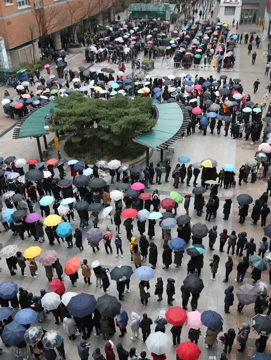 Orang-orang mengantre untuk membeli masker pelindung dari sebuah department store di Seoul, Jumat (28/2/2020). Penyebaran virus corona di Korea Selatan sendiri merupakan salah satu yang terbesar di luar China Daratan dengan kasus terkonfirmasi mencapai 1.766 orang per Jumat pagi ini. (YONHAP/AFP)