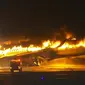 Sebuah pesawat Japan Airlines terbakar di landasan pacu bandara Haneda pada Selasa, 2 Januari 2024 di Tokyo, Jepang. (Screen grab video/AP)