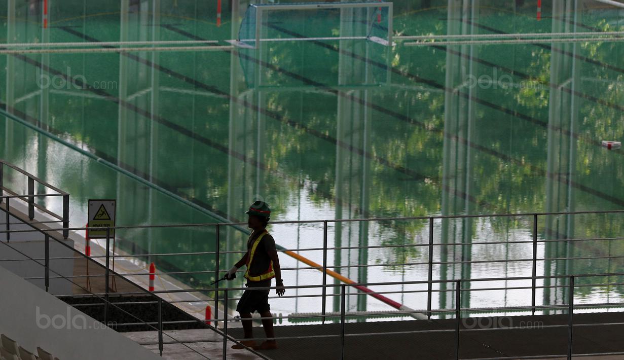 Seorang pekerja melintas dekat kolam Polo Air di Venue Aquatic Center, Senayan, Jakarta, (04/10/2017). Selain untuk rengan ada juga kolam untuk water polo pool dan lancet indah. (Bola.com/Nicklas Hanoatubun)