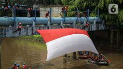 Sejumlah relawan membentangkan bendera Merah Putih di aliran kali
Ciliwung di kawasan Sudirman, Jakarta, Minggu (22/8/2021). Pembentangan atau pengibaran bendera Merah Putih tersebut dilaksanakan untuk memperingati HUT ke-76 RI. (Liputan6.com/Faizal Fanani)