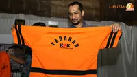 Ketua KPK, Abraham Samad tampak sedang memeriksa seragam baru KPK berupa baju lengan pendek bertuliskan Tahanan KPK di bagian belakang (Liputan6.com/Andrian M. Tunay)