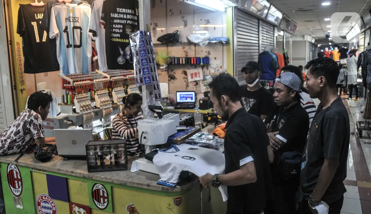 Pekerja menyelesaikan sablon jersey sepak bola di salah satu kios Blok B Pasar Tanah Abang, Jakarta Pusat, Kamis (8/12/2022). Selain Jakarta, permintaan jasa sablon jersey bertema Piala Dunia 2022 banyak dipesan dari luar Jawa hingga Papua. (merdeka.com/Iqbal S. Nugroho)
