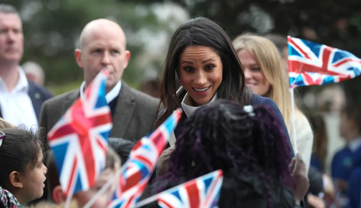 Meghan Markle menyapa anak-anak saat menghadiri sebuah acara yang diselenggarakan oleh perusahaan sosial Stemettes untuk merayakan Hari Perempuan Internasional di Millennium Point, Birmingham (8/3). (AFP Photo/Pool/Hannah Mckay)