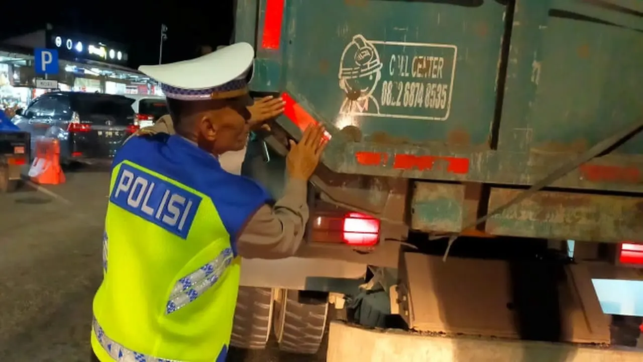 Personel Polda Riau memasang scot light di belakang kendaraan yang melintas di Tol Pekanbaru-Dumai untuk mencegah kecelakaan karena micro sleep.