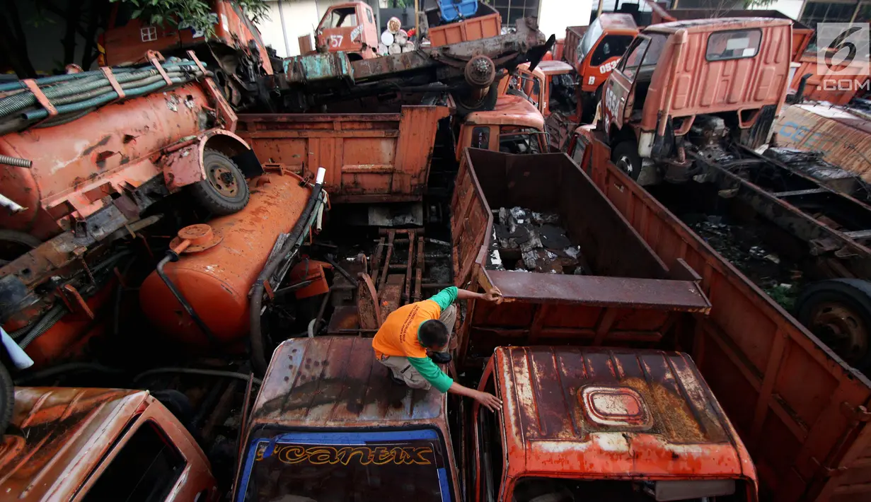 Petugas melakukan pengecekan bangkai armada truk sampah di Kantor Suku Dinas Lingkungan Hidup, Jakarta Barat, Selasa (27/3). Penumpukan armada tersebut dikarenakan kendaraan sudah tidak layak pakai. (Liputan6.com/JohanTallo)