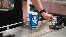Kaleng bir OTAN terlihat di lini produksi di tempat pembuatan bir Olaf di Savonlinna, Finlandia pada Kamis (19/5/2022). Bir OTAN Olaf Brewing menampilkan label biru dengan versi kartun ksatria abad pertengahan yang tengah meminum bir dengan baju besi yang dihiasi dengan simbol kompas NATO. (Alessandro RAMPAZZO / AFP)