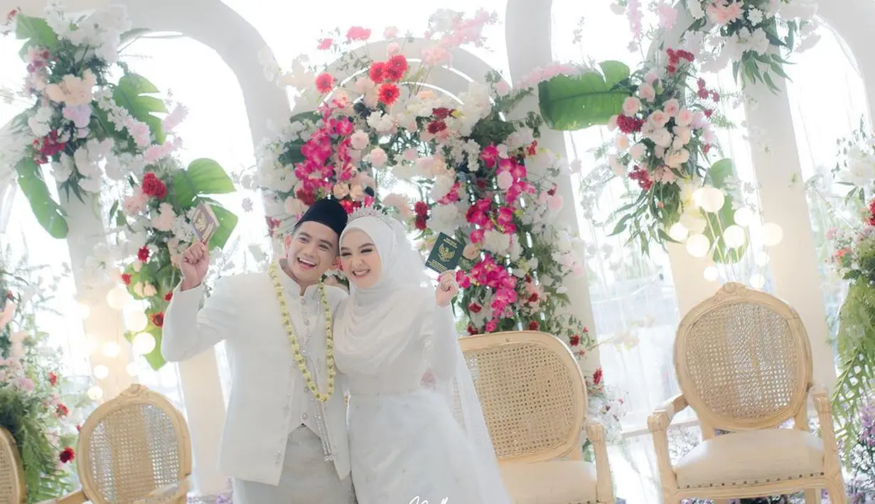 Lewat postingan di Instagram pribadinya, Rizki DA membagikan fotonya bersama sang istri dengan mengenakan busana pengantin Melayu serba putih.  [@da2_rizki123/@nadh.photography]