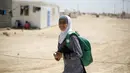 Omayma berjalan pulang sekolah di kamp pengungsi Al Zaatari, Mafraq, Yordania (21/4). Omayma Al Hushan menyerukan perlawanan terhadap pernikahan dini yang marak negaranya. (REUTERS / Muhammad Hamed)