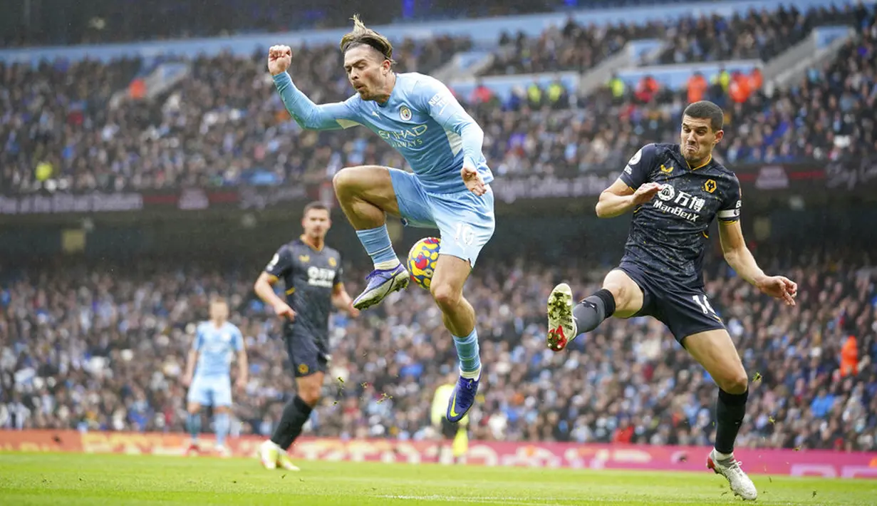 Pemain Manchester City Jack Grealish (kiri) berebut bola dengan pemain Wolverhampton Wanderers Conor Coady pada pertandingan sepak bola Liga Inggris di Etihad Stadium, Manchester, Inggris, 11 Desember 2021. Manchester City menang 1-0. (AP Photo/Dave Thompson)