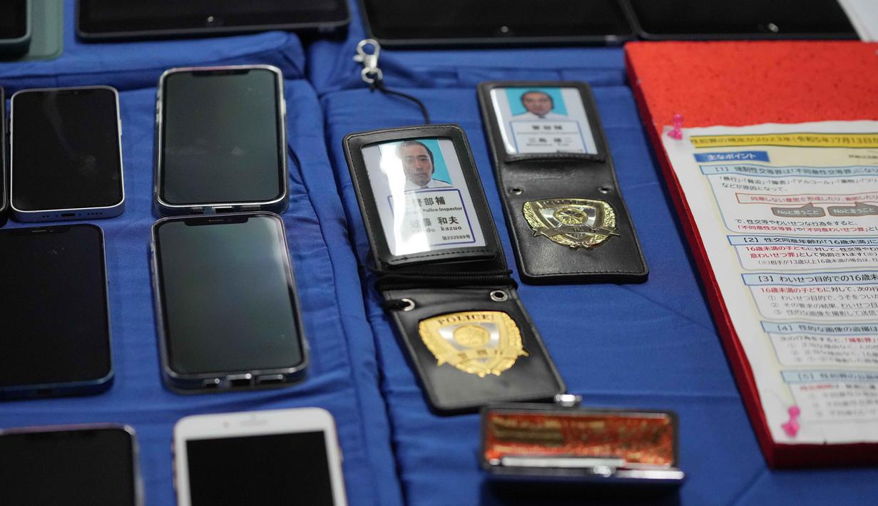 Para WNA ini diduga menjalankan praktik penipuan daring yang menyasar korban di negara asal mereka, yaitu Jepang. Tampak dalam foto, barang bukti, termasuk telepon seluler dan lencana polisi Jepang palsu, yang disita dari warga negara Jepang yang diduga terlibat dalam sindikat penipuan daring (online) diperlihatkan, di Bogor, Jawa Barat, Rabu 4 Maret 2026. (AP Photo/Achmad Ibrahim)