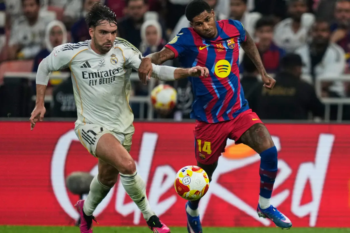 Pemain Real Madrid Raul Asencio (kiri) berduel memperebutkan bola dengan pemain Barcelona Marcus Rashford