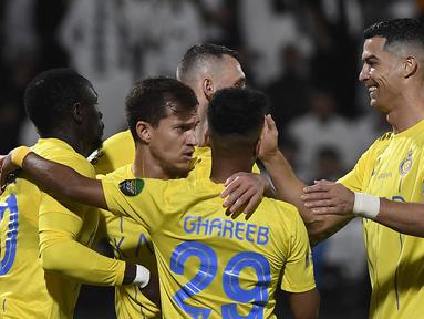 Cristiano Ronaldo (kanan) bersama pemain Al Nassr lainnya melakukan selebrasi setelah memenangkan pertandingan melawan Al Shabab dalam laga perempat final King's Cup Arab Saudi 2023 yang digelar di Al Shabab Club Stadium, Selasa (12/12/2023) dini hari WIB. (AFP/Str)