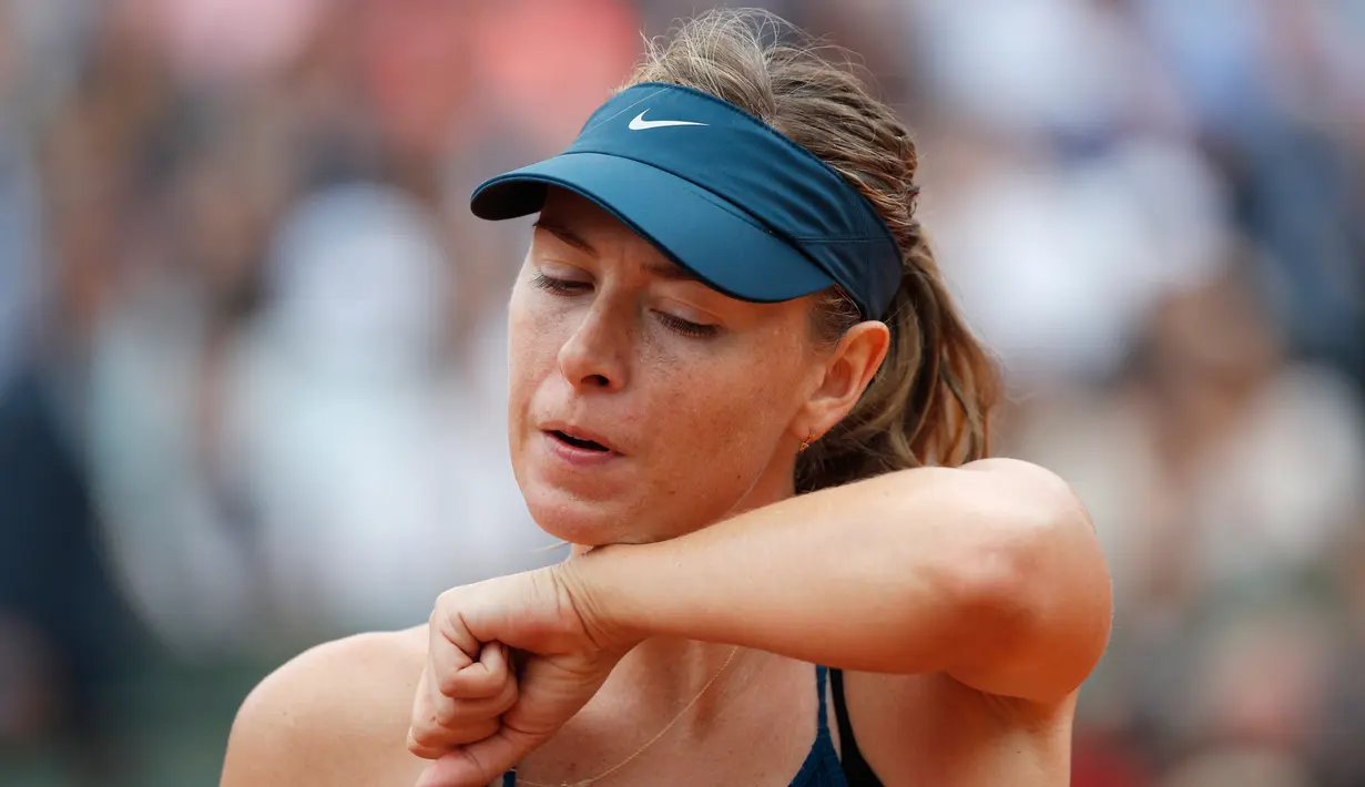 Petenis Rusia, Maria Sharapova mengusap keringat saat bertanding melawan Garbine Muguruza selama pertandingan perempat final turnamen tenis Prancis Terbuka di stadion Roland Garros,  Prancis (6/6). Garbine menang 6-2, 6-1. (AP Photo/Christophe Ena)