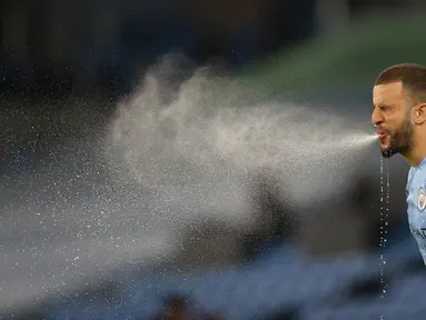 Pemain Manchester City, Kyle Walker menyemburkan air dari mulutnya saat pertandingan lanjutan Liga Inggris melawan Wolverhampton Wanderers. (Foto: AFP/Pool/Carl Recine)