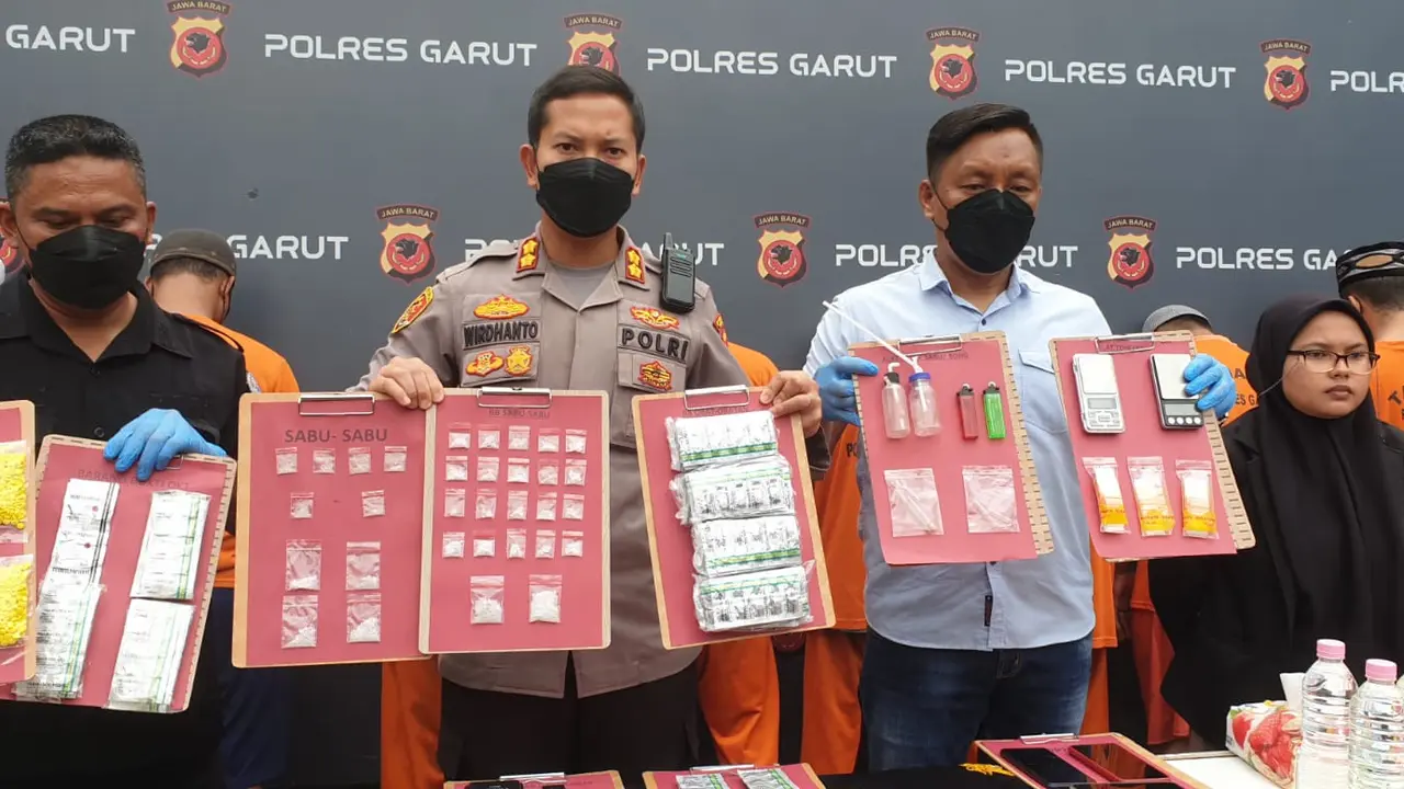 Kapolres Garut AKBP Wirdhanto Hadicaksono, didampingi Kasat Narkotika menunjukan barang bukti penyalahgunaan obat terlarang, dalam rilis kasus di Mapolres Garut, Kamis (15/12/2022). (Liputan6.com/Jayadi Supriadin)
