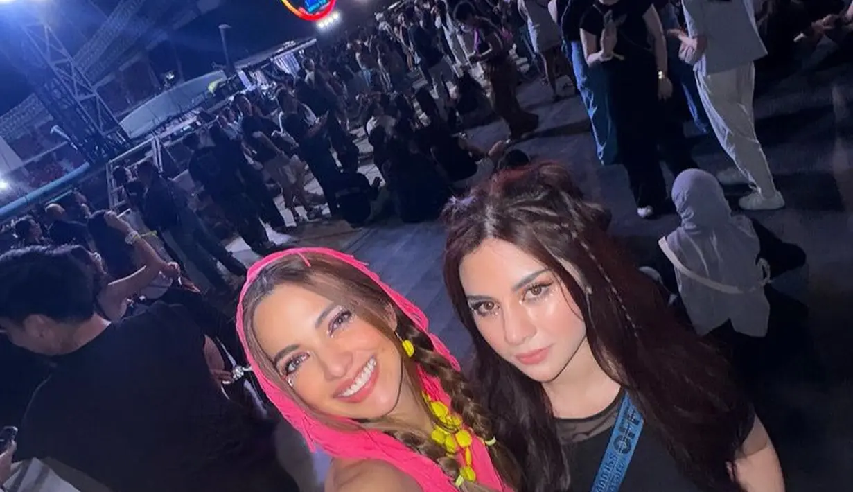 Dress pink tersebut memiliki hoodie yang dikenakan di atas rambut coklat bergaya kepang dua tanpa poni. [@ramadhaniabakrie]