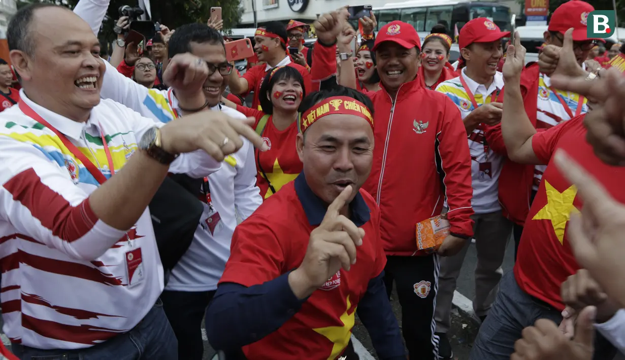 Suporter Timnas Indonesia U-22 dan Vietnam U-22 bernyanyi bersama jelang laga final SEA Games 2019 di Stadion Rizal Memorial, Manila, Selasa (10/12). Meski bersaing para suporter tetap akrab. (Bola.com/M Iqbal Ichsan)