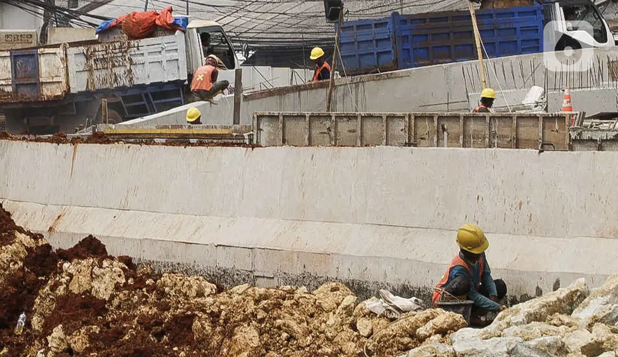 Pekerja menyelesaikan proses pembangunan underpass di Jalan Dewi Sartika, Depok, Jawa Barat, Rabu (16/11/2022). Progres pembangunan underpass yang melintang dari arah Dewi Sartika ke Jalan Margonda Raya dengan panjang penanganan 970 meter dan panjang underpass 470 meter itu sudah mencapai 70 Persen. (Liputan6.com/Herman Zakharia)