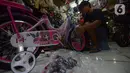 Aktivitas pekerja yang tengah merakit sepeda di toko sepeda Kramat Jati, Jakarta, Selasa (7/12/2021). Pandemi Covid-19 yang sedang terjadi membuat tren olahraga bersepeda semakin banyak diminati mulai dari anak-anak hingga orang dewasa dan lanjut usia. (merdeka.com/Imam Buhori)