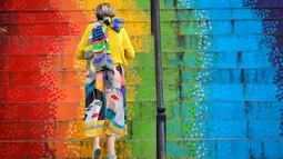 Seorang wanita berjalan menaiki tangga yang dicat dengan warna pelangi di Bucharest, Rumania, Sabtu (11/7/2020). Rumania melaporkan 698 infeksi COVID-19 baru dalam 24 jam terakhir, tingkat tertinggi sejak pandemi mencapai negara itu pada bulan Februari. (AP Photo/Vadim Ghirda)