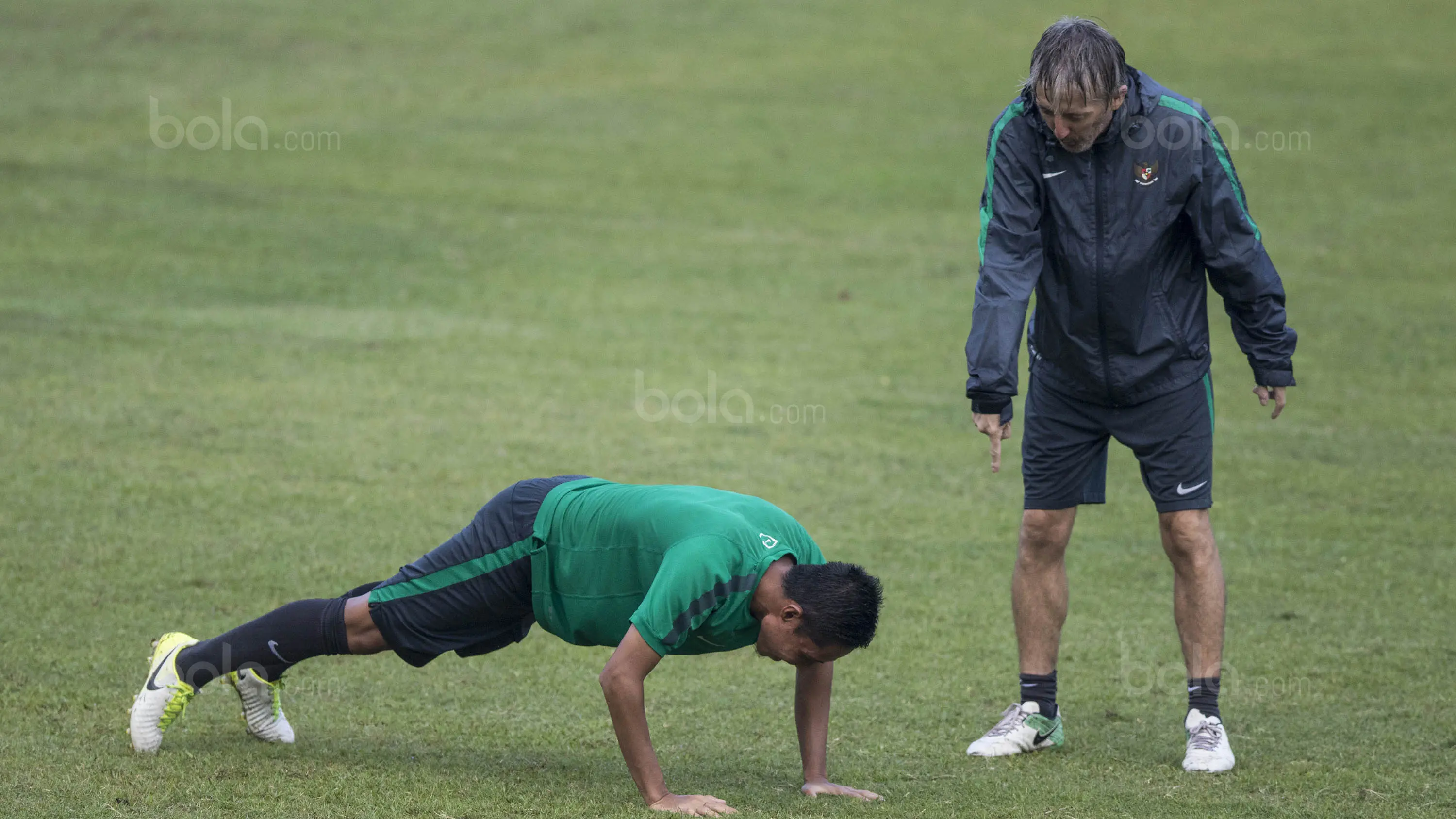 Gelandang Timnas Indonesia, Evan Dimas, diminta pelatih fisik, Miguel Gandia, untuk push up usai latihan di Stadion UKM, Selangor, Sabtu (19/8/2017). Evan kalah saat bermain crossbar dengan Miguel. (Bola.com/Vitalis Yogi Trisna)