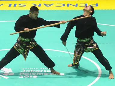 Pesilat Indonesia Yolla Primadona Jumpil dan Hendy beraksi dalam nomor seni ganda putra Asian Games 2018 di Padepokan Pencak Silat, TMII, Jakarta, Senin (27/8). Tim silat Indonesia meraih medali emas dengan skor 580. (Merdeka.com/Arie Basuki)