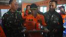Petugas dari Basarnas memegang sebuah kotak hitam atau Black Box dari helikopter Basarnas yang jatuh di Temanggung, Jawa Tengah (3/7). Helikopter yang membawa 8 orang tersebut jatuh saat perjalanan menuju lokasi letusan kawah Dieng. (AFP Photo/STR)