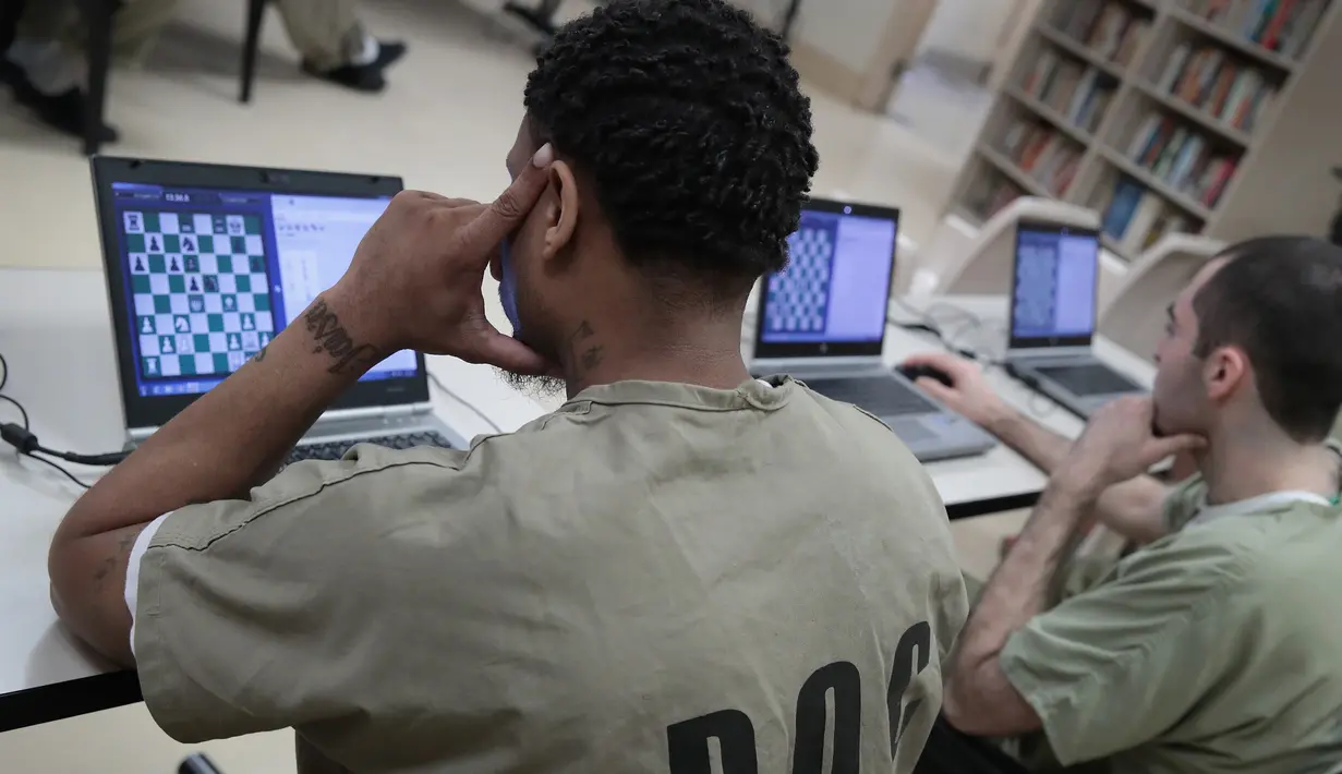 Sejumlah narapidana penjara Cook County terlihat serius saat mengikuti turnamen catur internasional secara online melawan Penjara Viana dari Brasil di Chicago, Illinois (17/5). (Scott Olson/Getty Images/AFP)