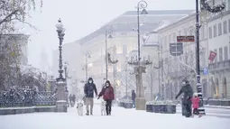 Sejumlah warga berjalan di Kota Tua saat hujan salju pertama mengguyur Warsawa, Polandia, pada 10 Desember 2020. Warsawa menyambut salju pertamanya tahun ini pada Kamis (10/12). (Xinhua/Jaap Arriens)