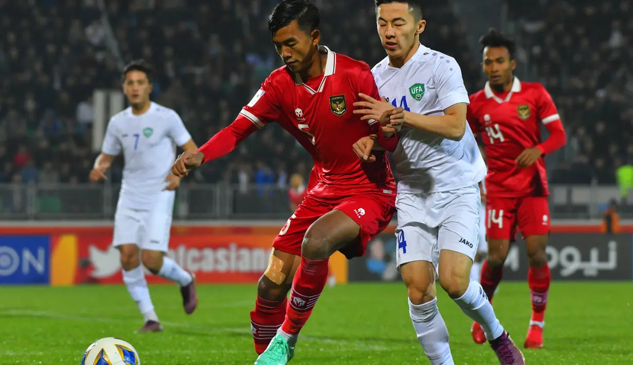 Pemain belakang timnas Indonesia U-20, Kakang Rudianto (kiri) berusaha menahan laju pemain Uzbekistan, Abbosbek Fayzullaev pada laga terakhir Grup A Piala Asia U-20 di Stadion Istiqlol Fergana, Uzbekistan, Selasa (7/3/2023). Garuda Muda gagal mencetak gol dalam laga yang tuntas 0-0. Hasil ini membuat Indonesia tersingkir dari ajang Piala Asia U-20. (Foto: Dok PSSI)