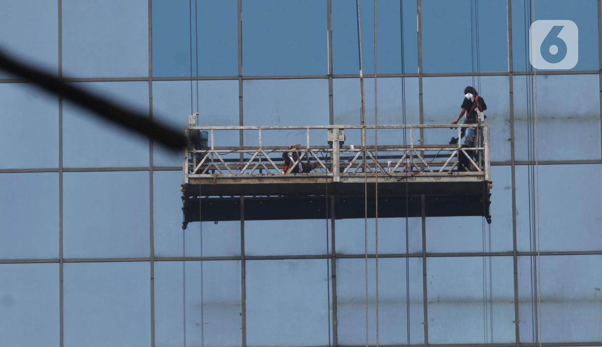 Pekerja membersihkan kaca gedung di Jenderal Sudirman Kawasan Semanggi, Jakarta Sabtu (29/7/2023). Berdasarkan data Air Quality Indek (AQI), Polusi udara Jakarta kembali masuk kategori "Tidak Sehat" dan masuk tiga besar di dunia. (merdeka.com/Imam Buhori)