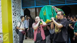 Para kerabat menggotong keranda alm Guntoro di Lenteng Agung, Jakarta, Kamis (16/2). Diduga terkena serangan jantung , Guntoro, wartawan foto, Koran Jakarta meninggal dunia saat meliput banjir di daerah Pejaten Timur. (Liputan6.com/Faizal Fanani)