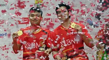 Ganda putra Indonesia, Leo Rolly Carnando (kiri) dan Daniel Marthin berpose di podium kemenangan setelah mengalahkan Kim Astrup dan Anders Skaarup Rasmussen dari Denmark pada final turnamen bulu tangkis Indonesia Masters di Jakarta, 28 Januari 2024. (ADEK BERRY/AFP)