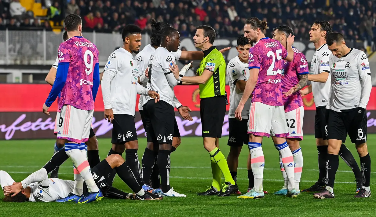 Pemain Spezia Emmanuel Gyasi (tengah kiri) berdebat dengan wasit Federico La Penna saat melawan Juventus pada pertandingan sepak bola Liga Italia di Stadion Alberto-Picco, La Spezia, Italia, 19 Februari 2023. Juventus mengalahkan Spezia dengan skor 2-0. (ANDREAS SOLARO/AFP)