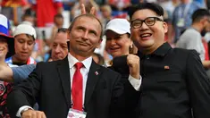 Peniru Presiden Rusia, Vladimir Putin dan pemimpin Korea Utara, Kim Jong-un berpose selama menyaksikan laga penyisihan Grup A Piala Dunia 2018 antara Uruguay vs Rusia di Samara Arena, Senin (25/6). Uruguay berhasil melumat Rusia 3-0. (AFP/EMMANUEL DUNAND)